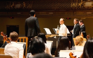 El director de orquesta Yohei Sato y los trompetistas (de izq. a der.) Alexander Wilson, Eric Robins y Kaspar Martig ensayan 'Bugler's Holiday' de Leroy Anderson.