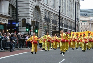 ロンドンでの新年パレードで、法輪功の修煉者と一緒に腰太鼓を叩くベン・チェン（右前）。ピカデリーを数百名におよぶ様々なグループがパレードした。