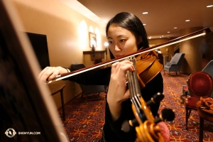 Violinist Karen Chen in focused preparation. Performers like Ms. Chen — even as she closes in on 100 performances this year alone and with 11 such Shen Yun seasons under her belt — are always striving to further perfect their art. (Photo by Annie Li)