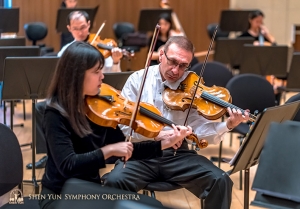 Principal violist Vardan Petrosyan (right) and assistant principal violists Rachel Chen review a section of the repertoire.  (Photo by TK Kuo)
