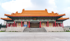 The full grandeur of Taiwan's National Concert Hall with its golden roof, upturned eaves, and massive red colonnades, reminiscent of the palaces of the Ming and Qing Dynasties of China (1368–1912).