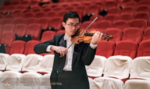Violinist Ian Zhong warms up before the concert.