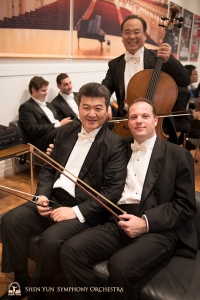 Principal bassist Juraj Kukan (R) and bassist Wei Liu wait to be reunited with their instruments on stage—cellist James Zheng doesn't need to wait.