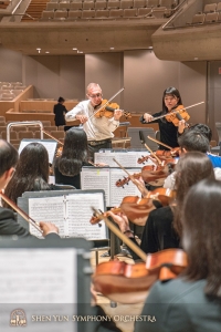 Principal violist Vardan Petrosyan and assistant principal violist Rachel Chen hold an impromptu sectional after rehearsal.