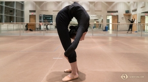 Principal dancer Evangelina Zhu warms up by folding herself in half. (Photo by Percussionist Tiffany Yu)
