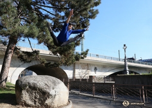 A dancer leaps from a rock in Geneva&mdash;fingers crossed for a soft landing! (Photo by Nick Zhao)