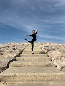 Dancer Daoyong Zheng poses on the stone steps near the beach. (Photo by projectionist Annie Li)