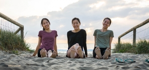 Dancers (from left) Liz Lu, Michelle Wu, and Daniella Wollensak get up early and enjoy some sand between their toes.