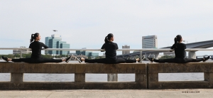 Dancers (left to right) Kaidi Wu, Eva Su, and Cecilia Wang find comfy seats to watch the boats go by. (Photo by Diana Teng)
