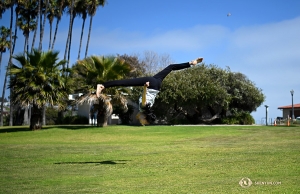 Taking advantage of the open space at Dana Point Harbor, Principal Dancer Elsie Shi performs a flip in the field. (Photo by Annie Li)
