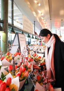 Amidst the hustle and bustle of the famed Pike Place Market in Seattle, Dancer YuHui takes a moment to admire the beauty of the vibrant flowers. Think you haven't heard of the Pike Place market? Think Starbucks.