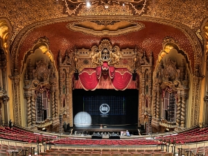 The empty stage in Ohio Theatre lies in quiet anticipation, bathed in the glow of golden decor.