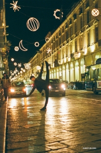 La elegante silueta de un bailarín se destaca entre las mágicas luces de Luci d'Artista, una instalación de arte al aire libre en Turín, Italia.